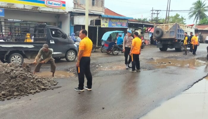 Bersama Warga, Personil Polsek Tanjung Pura Timbun Jalan Berlubang